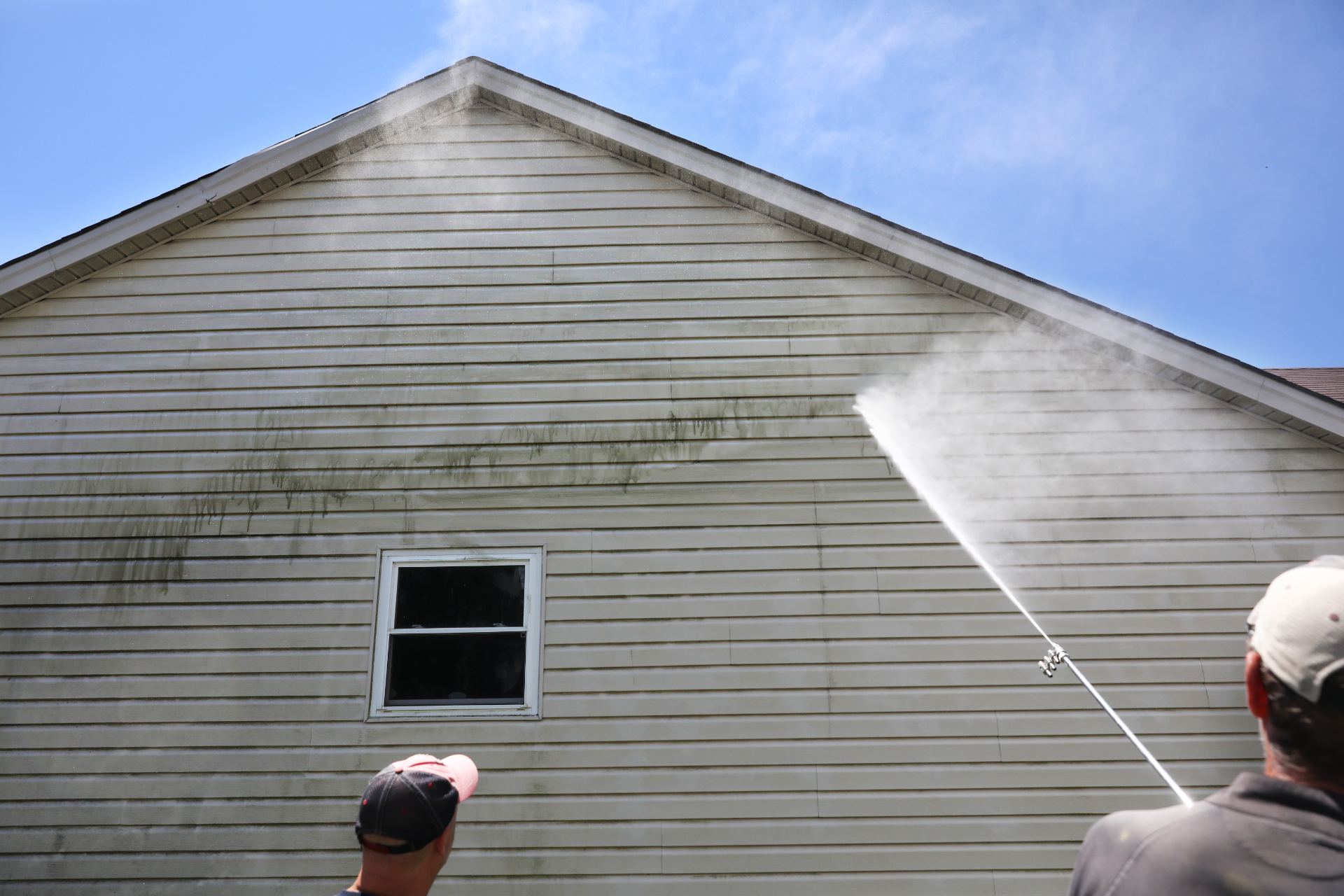 Professional power washing service cleaning mildew from house siding