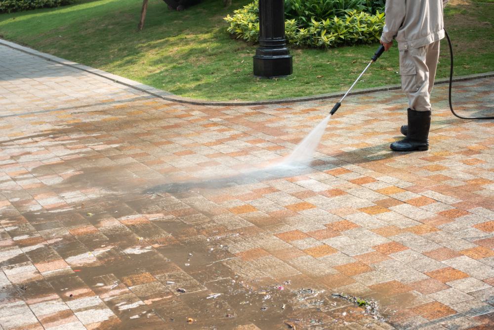 Professional power washing cleaning brick patio with high-pressure water spray
